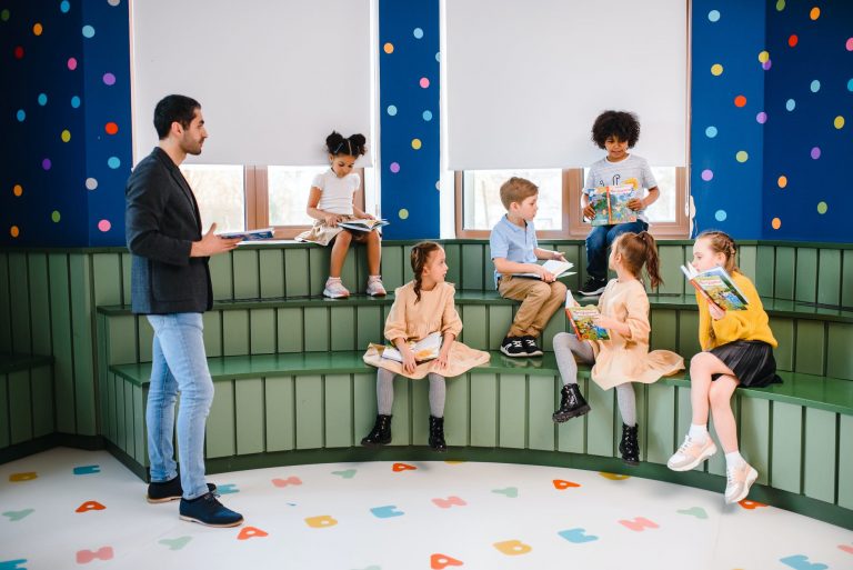 children and man reading books together