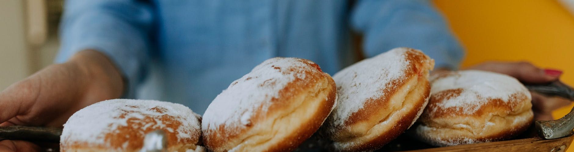 photo of person carrying tray of doughnuts