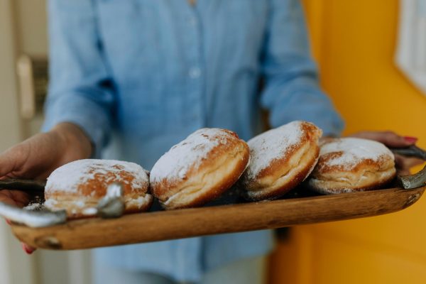 photo of person carrying tray of doughnuts