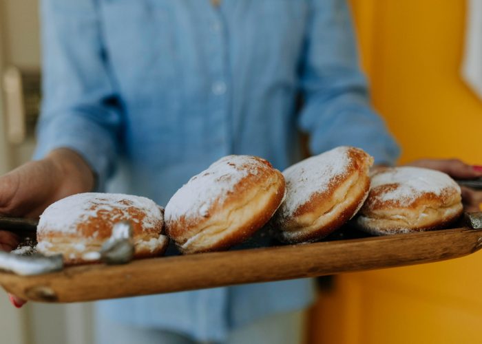 photo of person carrying tray of doughnuts