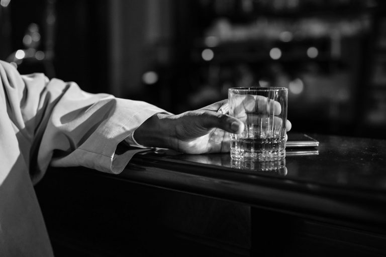 close up photo of person holding clear drinking glass