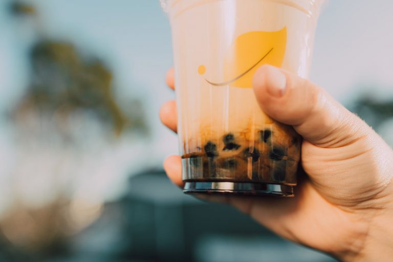 a close up shot of a person holding a milk tea