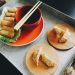 fried spring rolls and dumplings on top of tray