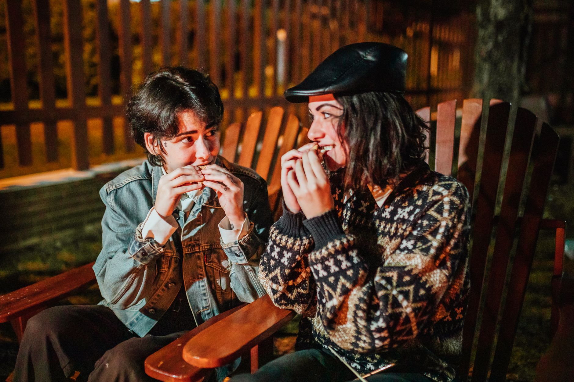girlfriends enjoying smores in armchairs at night