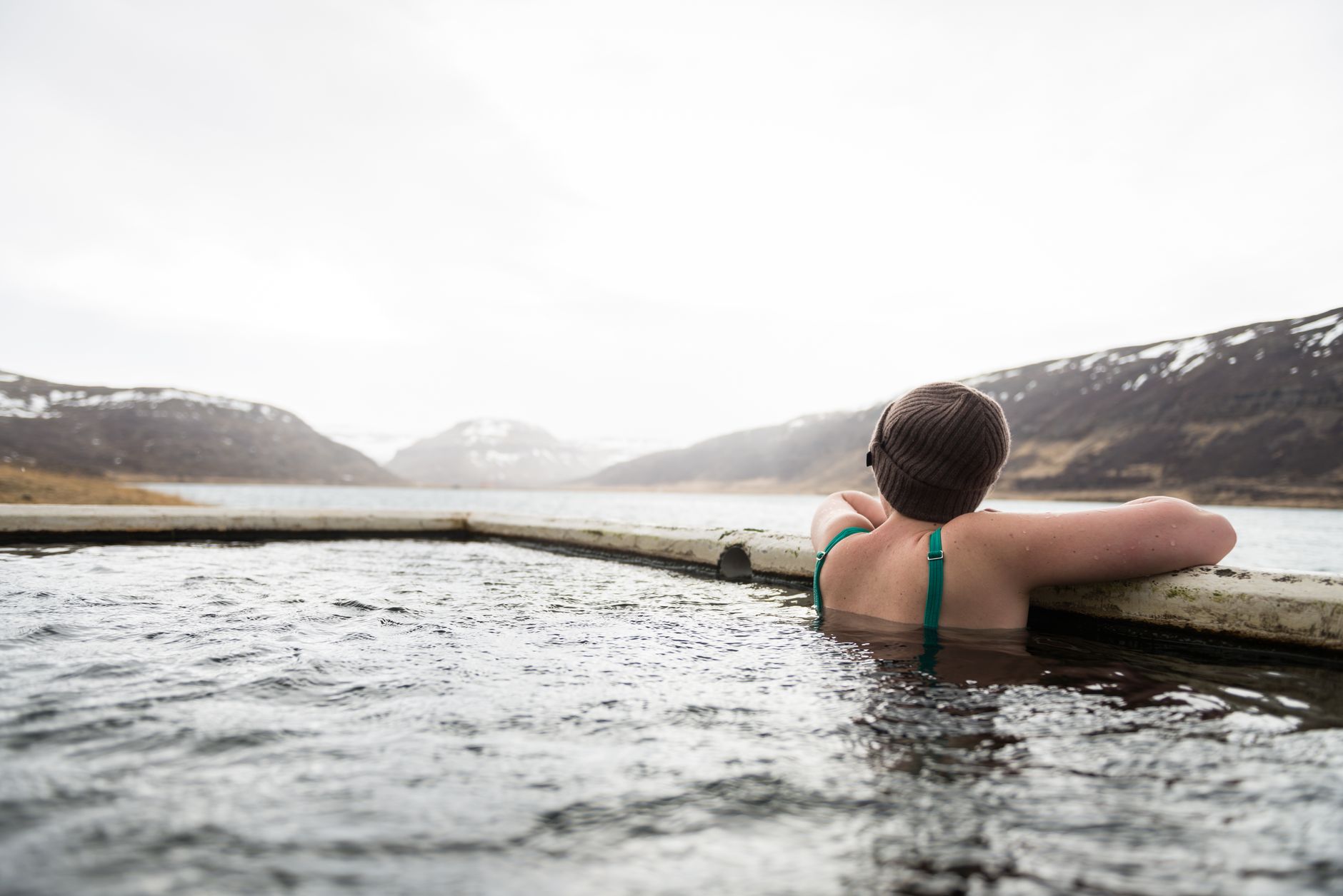 a person wearing knit cap soaking in a pool