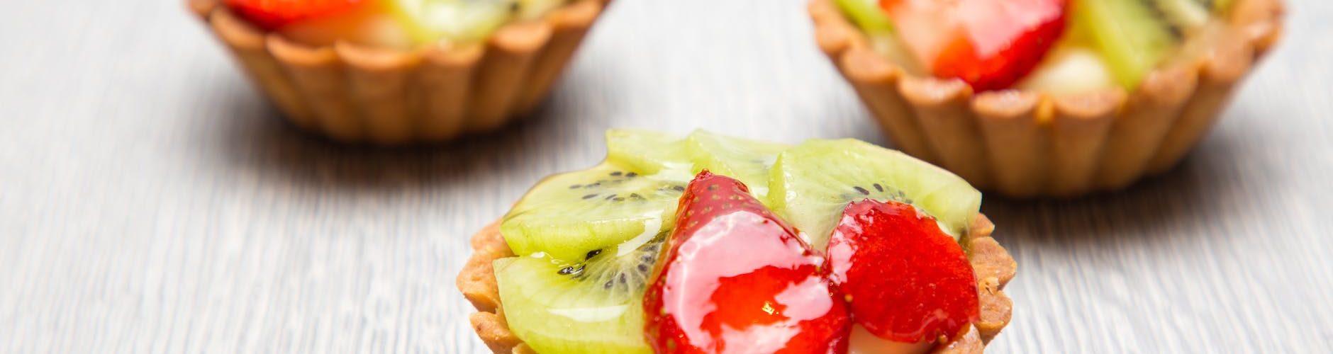 close up photography of three kiwi topped tarts