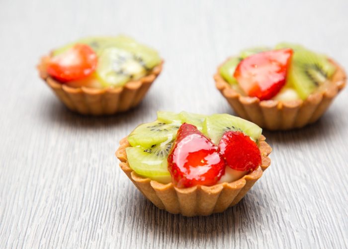 close up photography of three kiwi topped tarts