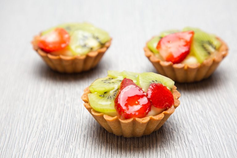 close up photography of three kiwi topped tarts