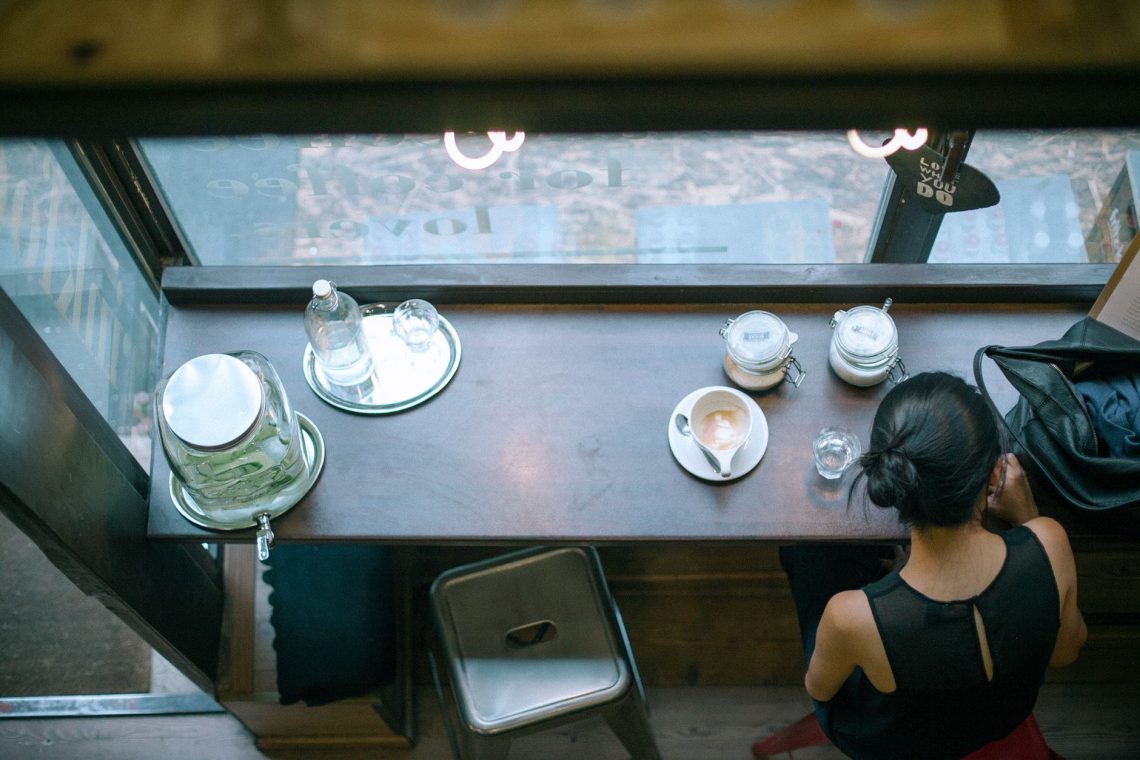 unrecognizable female sitting in cafe with coffee