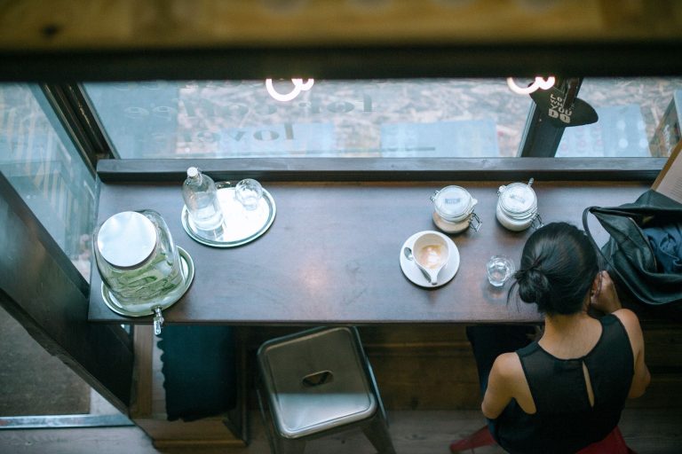 unrecognizable female sitting in cafe with coffee